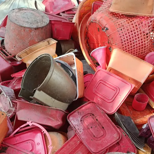 Pile of sorted red and pink plastic lids, baskets and buckets